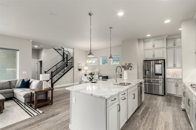 21492 E 60th Ave, Aurora, CO 80019 - kitchen with a sink, light wood-style flooring, open floor plan, and appliances with stainless steel finishes