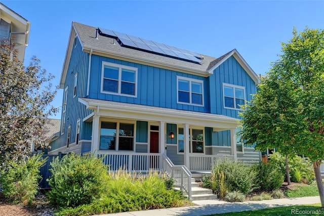 view of front of house featuring solar panels, a porch, and board and batten siding