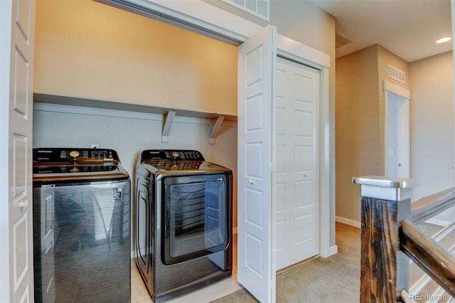 laundry room with light carpet, laundry area, washing machine and dryer, and visible vents