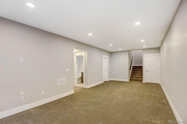 below grade area featuring visible vents, baseboards, stairway, carpet, and recessed lighting