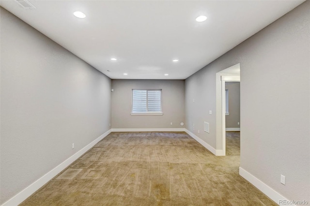 empty room featuring recessed lighting, visible vents, baseboards, and light colored carpet