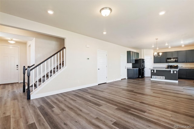 9805 Granite Park Ln, Peyton, CO 80831 - unfurnished living room featuring stairway, wood finished floors, and recessed lighting