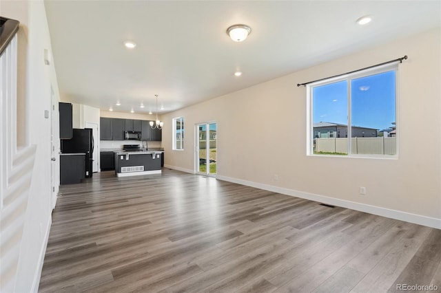 9805 Granite Park Ln, Peyton, CO 80831 - unfurnished living room featuring wood finished floors and recessed lighting