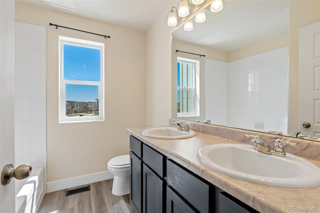 9805 Granite Park Ln, Peyton, CO 80831 - full bathroom with double vanity, wood finished floors, and washtub / shower combination