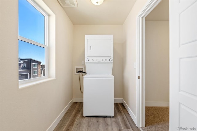 9805 Granite Park Ln, Peyton, CO 80831 - laundry room with stacked washer and clothes dryer and wood finished floors