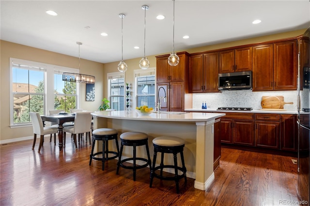 10681 Sundial Rim Rd, Highlands Ranch, CO 80126 - kitchen with stainless steel appliances, a sink, light countertops, a kitchen breakfast bar, and tasteful backsplash
