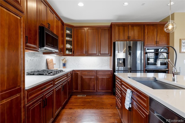 10681 Sundial Rim Rd, Highlands Ranch, CO 80126 - kitchen with a sink, appliances with stainless steel finishes, light countertops, dark wood-type flooring, and recessed lighting