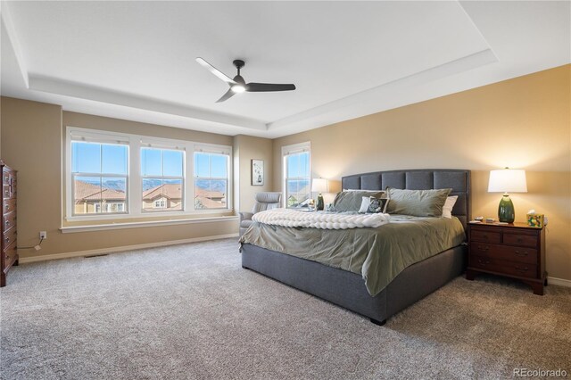 10681 Sundial Rim Rd, Highlands Ranch, CO 80126 - carpeted bedroom featuring a tray ceiling, baseboards, and a ceiling fan