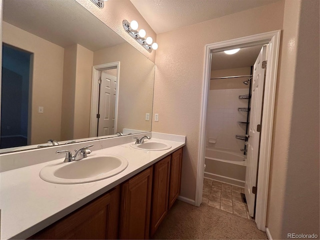 bathroom featuring a textured ceiling, vanity, and  shower combination