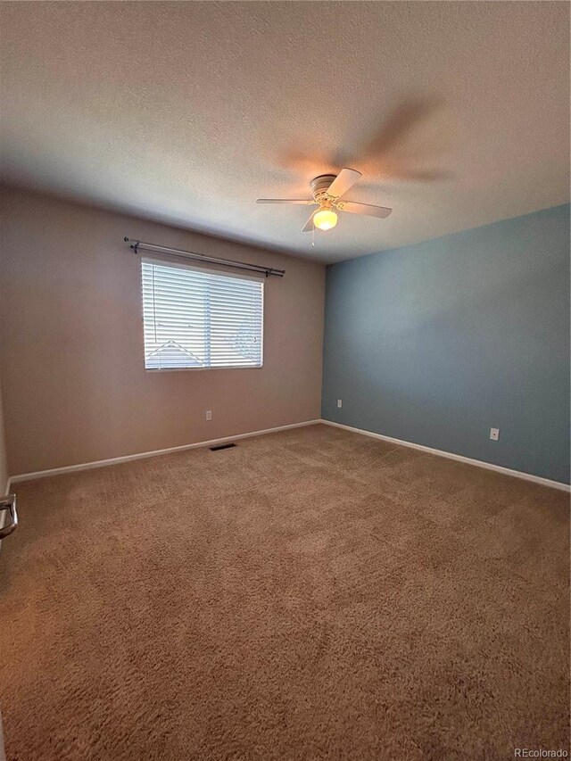 carpeted empty room featuring ceiling fan and a textured ceiling