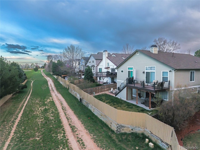 back of house with stairs, a wooden deck, and a residential view