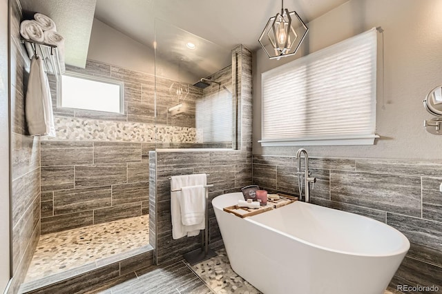 full bath with tile walls, a freestanding tub, a walk in shower, and wainscoting