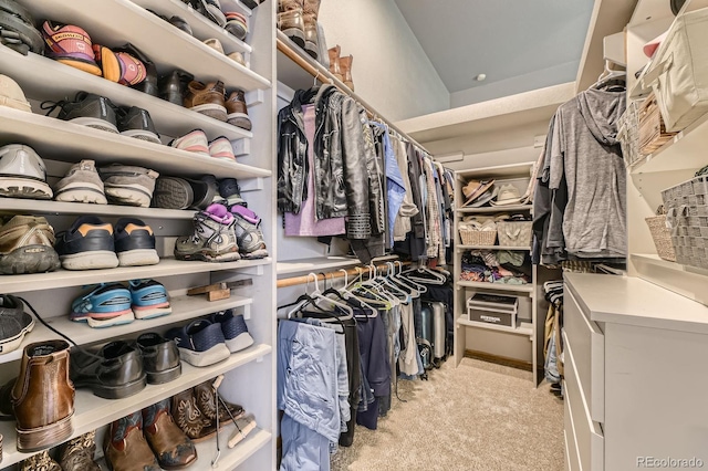 walk in closet featuring light colored carpet