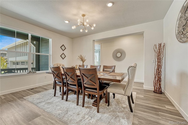 17194 Desert Wine Ln, Parker, CO 80134 - dining room with a chandelier, wood finished floors, plenty of natural light, and a textured ceiling