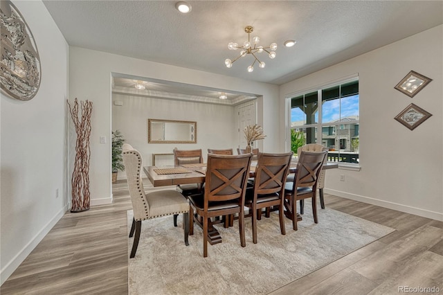 17194 Desert Wine Ln, Parker, CO 80134 - dining space with a chandelier, light wood-style floors, and a textured ceiling