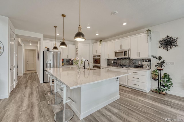 17194 Desert Wine Ln, Parker, CO 80134 - kitchen with appliances with stainless steel finishes, light wood-style floors, white cabinets, recessed lighting, and tasteful backsplash