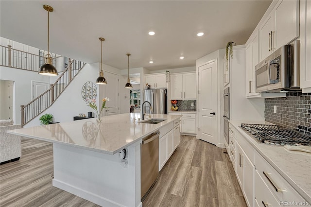 17194 Desert Wine Ln, Parker, CO 80134 - kitchen with appliances with stainless steel finishes, light wood-style flooring, decorative backsplash, white cabinets, and recessed lighting
