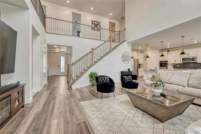17194 Desert Wine Ln, Parker, CO 80134 - living room featuring stairs, light wood-type flooring, recessed lighting, and a high ceiling