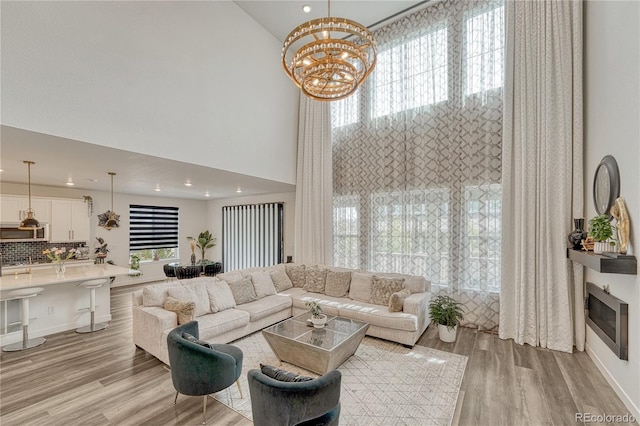 17194 Desert Wine Ln, Parker, CO 80134 - living room featuring plenty of natural light, light wood-type flooring, recessed lighting, a chandelier, and a towering ceiling