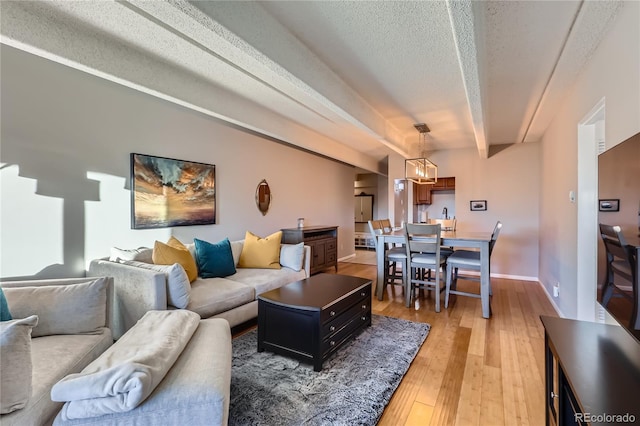 living room with beamed ceiling, hardwood / wood-style flooring, and a textured ceiling