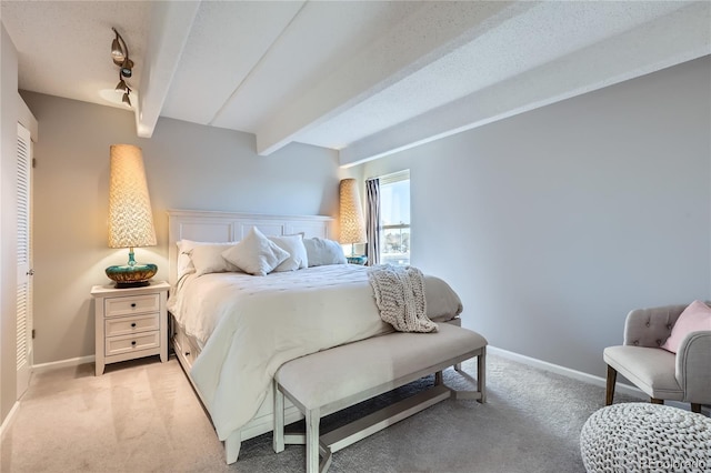 bedroom featuring light colored carpet and beamed ceiling