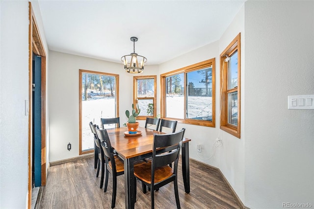 dining area featuring dark hardwood / wood-style floors and an inviting chandelier