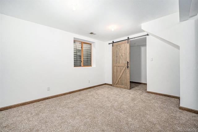 unfurnished bedroom with light carpet and a barn door