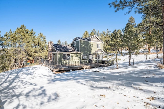 snow covered house featuring a deck