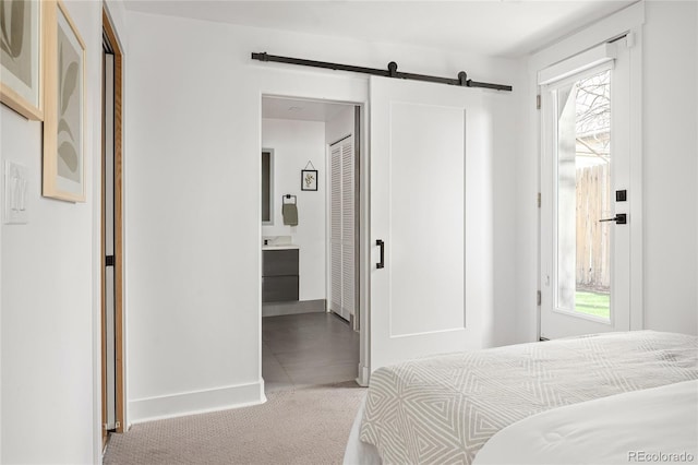 1755 Ingalls St, Lakewood, CO 80214 - bedroom with carpet floors, a barn door, multiple windows, and baseboards