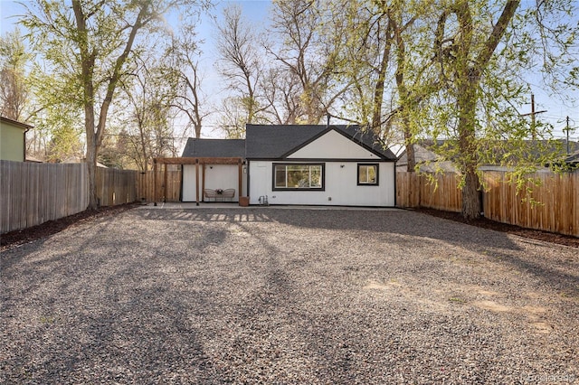 1755 Ingalls St, Lakewood, CO 80214 - rear view of house featuring gravel driveway and a fenced backyard