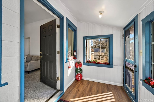 entryway featuring lofted ceiling, dark hardwood / wood-style floors, and ornamental molding