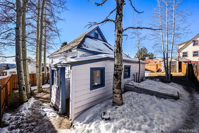 view of snow covered exterior with a storage shed