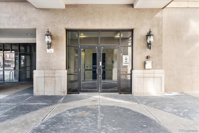 property entrance featuring french doors and stucco siding