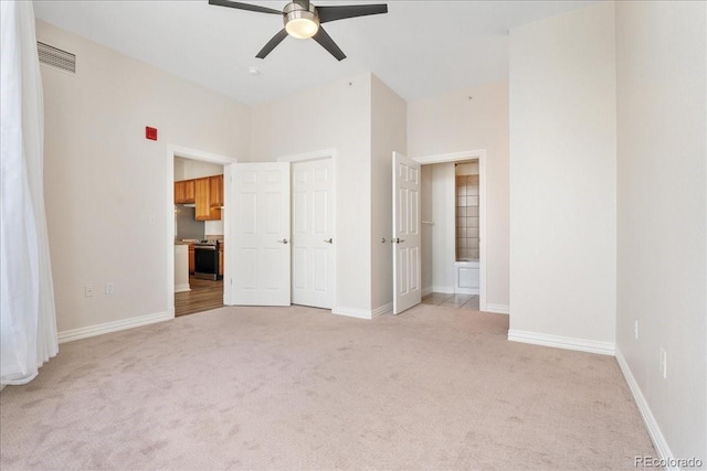 unfurnished bedroom with baseboards, ensuite bath, visible vents, and light colored carpet