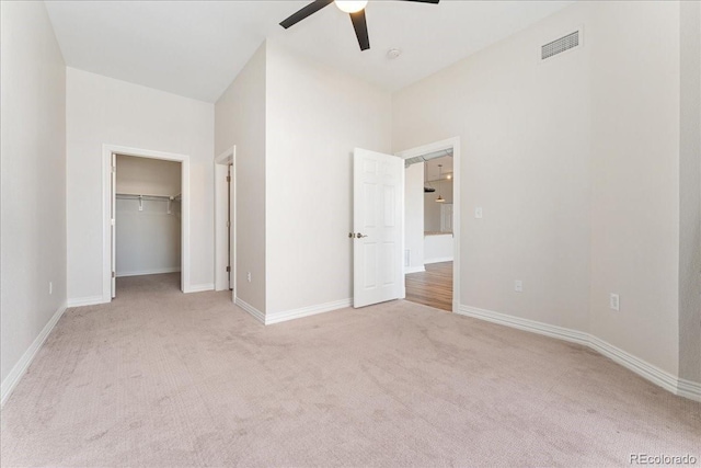 unfurnished bedroom featuring light carpet, baseboards, visible vents, and a ceiling fan