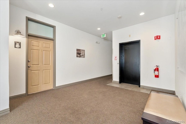 empty room featuring elevator, carpet, baseboards, and recessed lighting