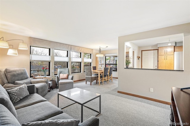 carpeted living area with baseboards