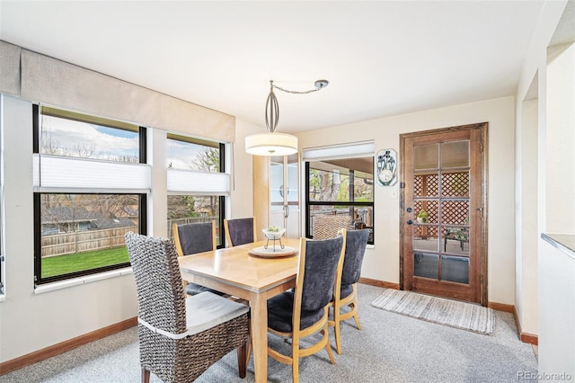 carpeted dining area featuring baseboards