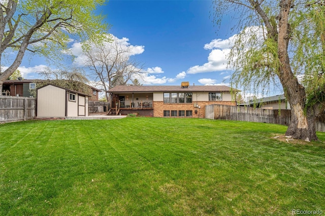 rear view of house with a lawn, an outbuilding, brick siding, a fenced backyard, and a shed