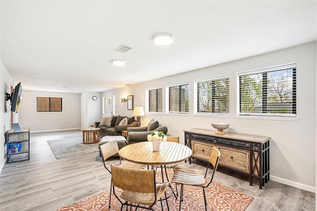dining space with visible vents, baseboards, and wood finished floors