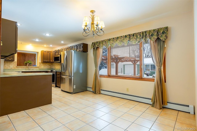 kitchen with sink, decorative light fixtures, appliances with stainless steel finishes, a notable chandelier, and light tile patterned flooring