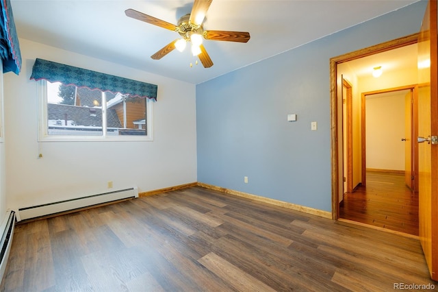 spare room featuring ceiling fan, wood-type flooring, and a baseboard heating unit