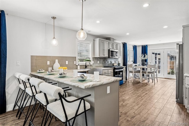 5202 Reed St, Arvada, CO 80002 - kitchen with stainless steel appliances, tasteful backsplash, a peninsula, a sink, and recessed lighting