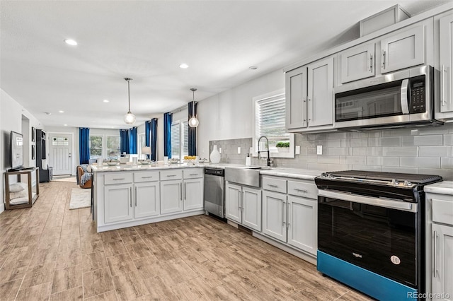 5202 Reed St, Arvada, CO 80002 - kitchen with appliances with stainless steel finishes, a sink, a peninsula, healthy amount of natural light, and recessed lighting