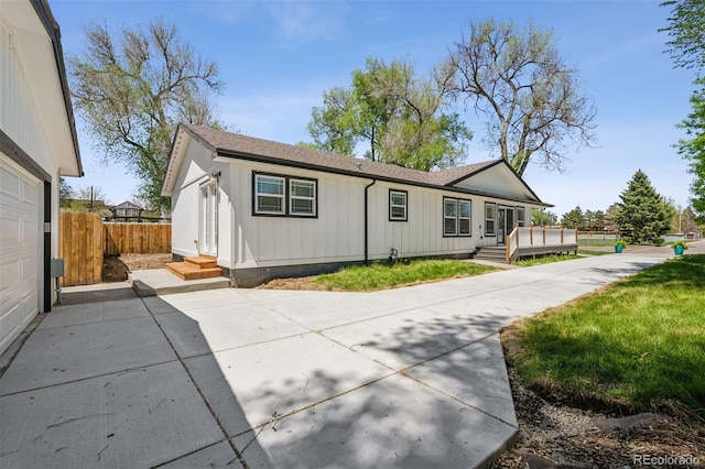 5202 Reed St, Arvada, CO 80002 - back of property featuring fence, board and batten siding, a deck, and roof with shingles