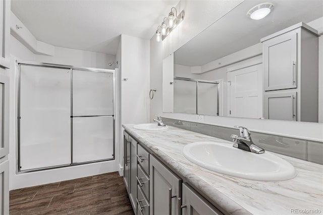 5202 Reed St, Arvada, CO 80002 - bathroom featuring a shower stall, double vanity, and wood finished floors