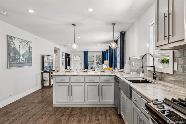 5202 Reed St, Arvada, CO 80002 - kitchen with a peninsula, appliances with stainless steel finishes, a sink, dark wood-style flooring, and recessed lighting
