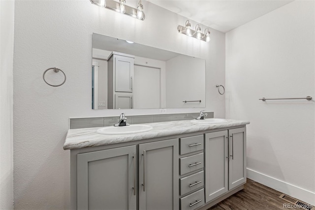 5202 Reed St, Arvada, CO 80002 - bathroom featuring baseboards, double vanity, and wood finished floors