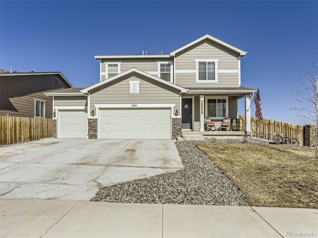 5995 Fencerow Pl, Brighton, CO 80601 - traditional-style home with a porch, a garage, concrete driveway, and stone siding