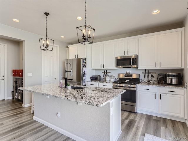 5995 Fencerow Pl, Brighton, CO 80601 - kitchen with appliances with stainless steel finishes, a chandelier, a sink, light wood-type flooring, and white cabinetry
